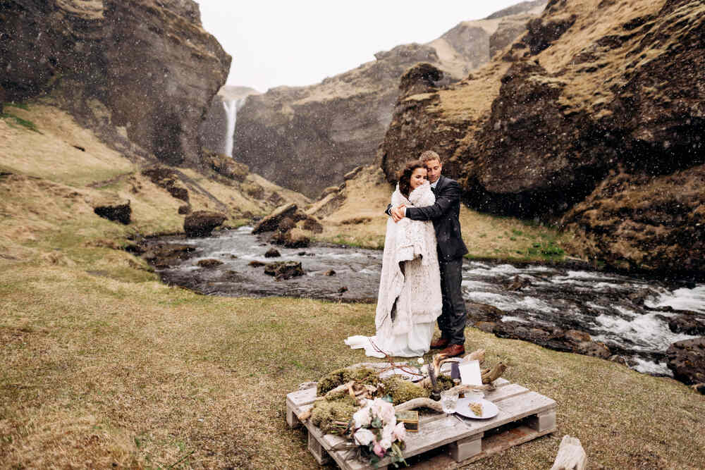 Una coppia in un ambiente rurale, vicino a un ruscello e una cascata, con dettagli di nozze rustiche e naturali. Un connubio perfetto tra tradizione e natura.